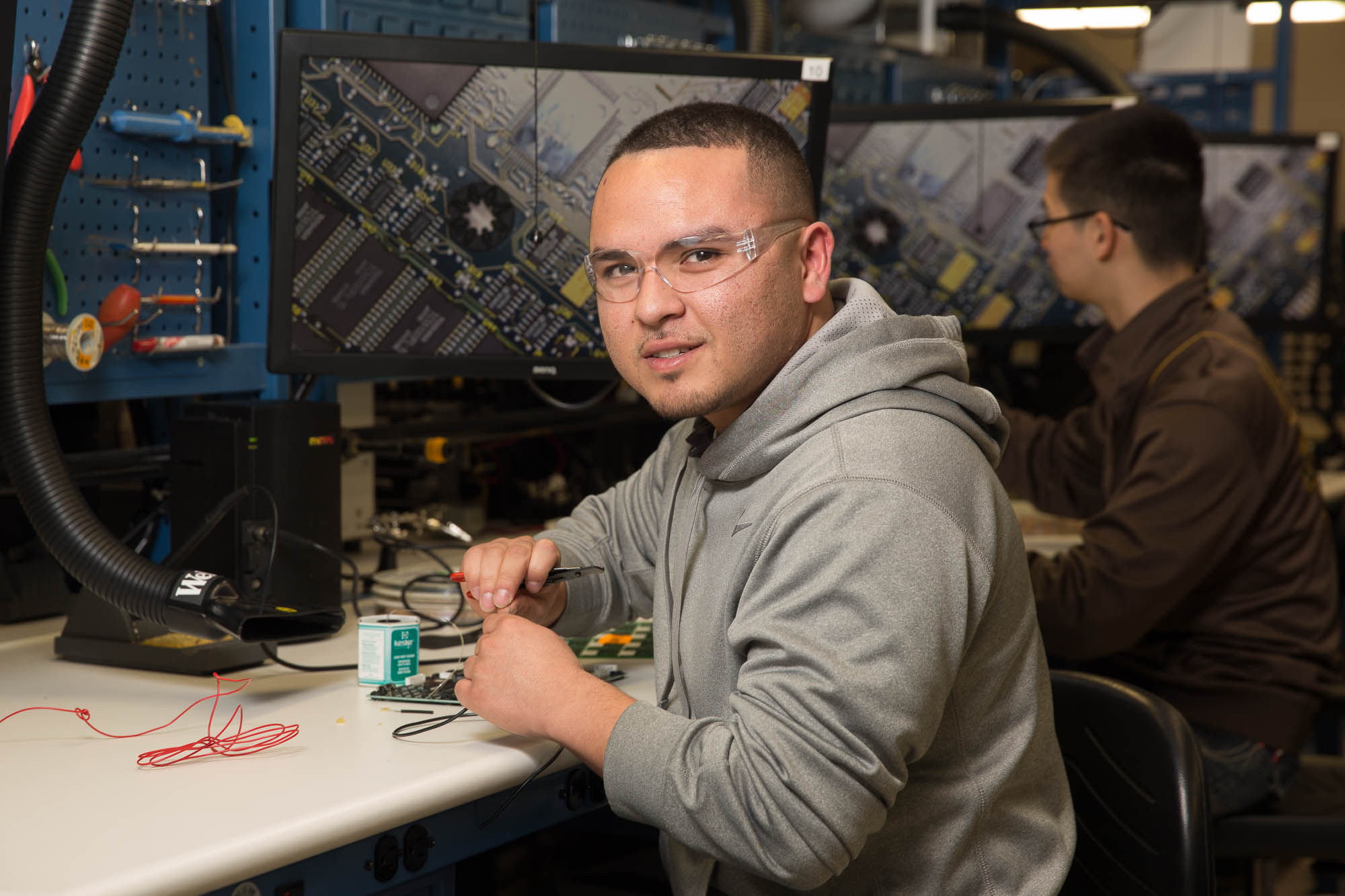 Student in safety glasses sitting and working